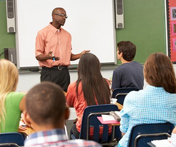 Image of teacher facing classroom teaching students using accessible materials for STEM textbooks and exams.
