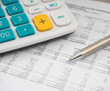 Image of financial documents with calculator depicting monthly statements.