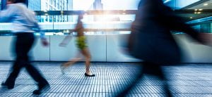 Image of people walking quickly along an office corridor depicting speed of high-quality accessible communications.