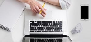 Image of hand on laptop keyboard depicting someone learning about accessible communications online.