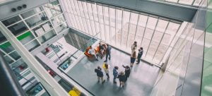 Image of people gathered in the lobby of an office setting (bird’s-eye view).