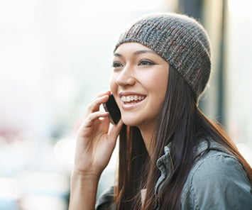 Image of woman smiling, talking on a mobile phone, representing customer activity in the telecommunications industry